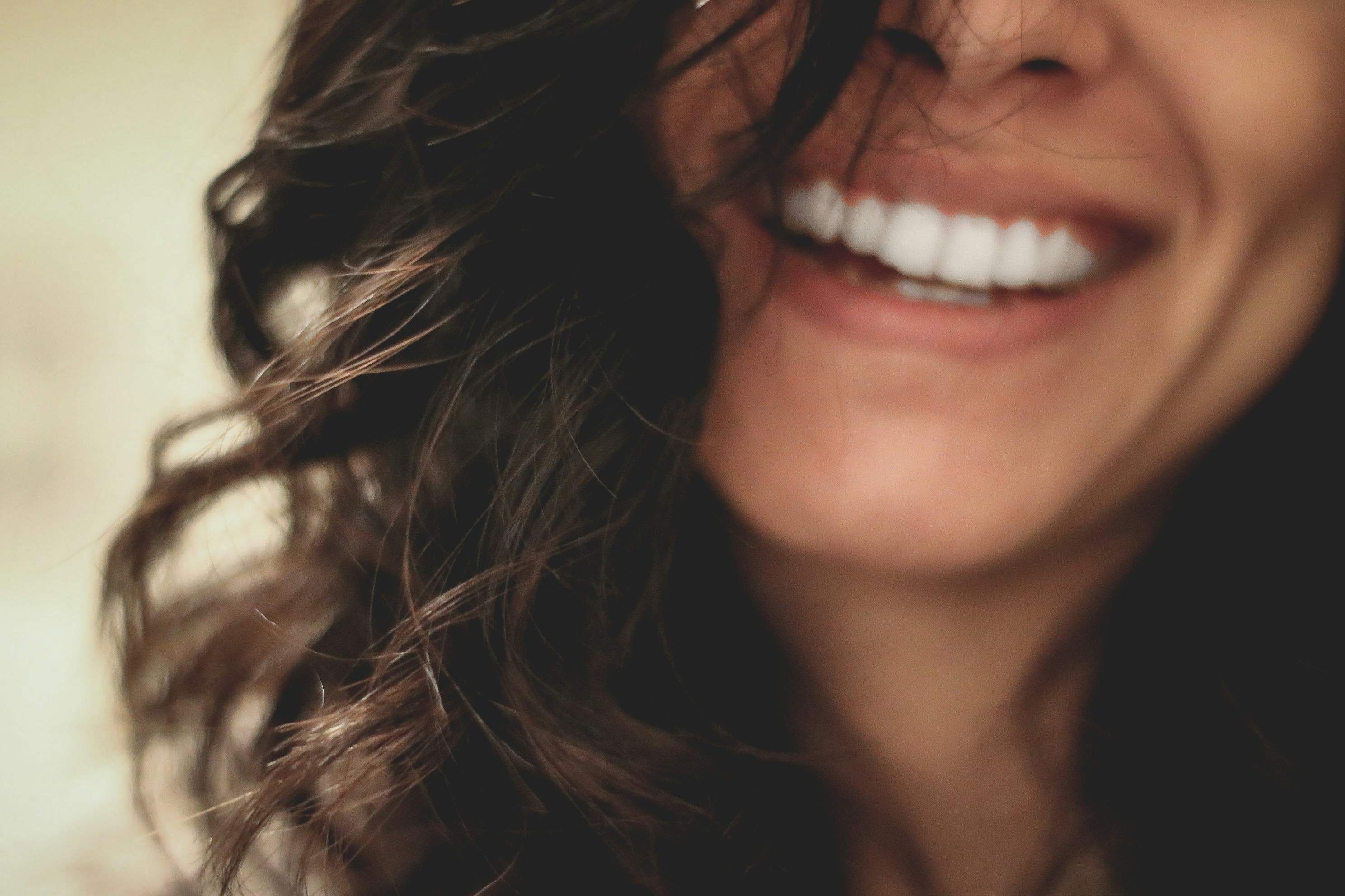 Close-up of a smiling woman showing healthy white teeth, symbolizing the benefits of dental care and insurance coverage