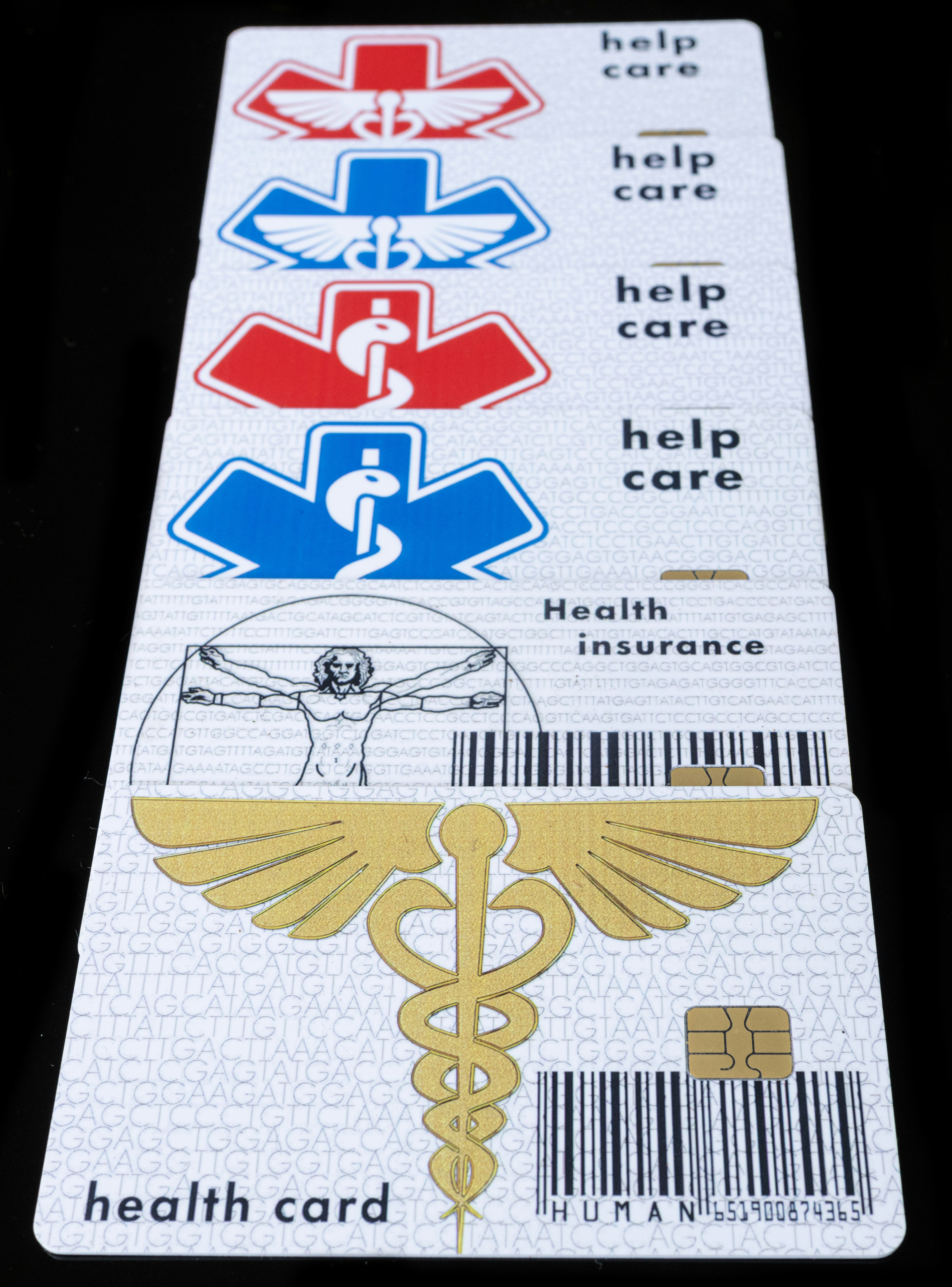 Stack of health insurance cards with medical symbols, including caduceus and healthcare logos, representing different types of health coverage.